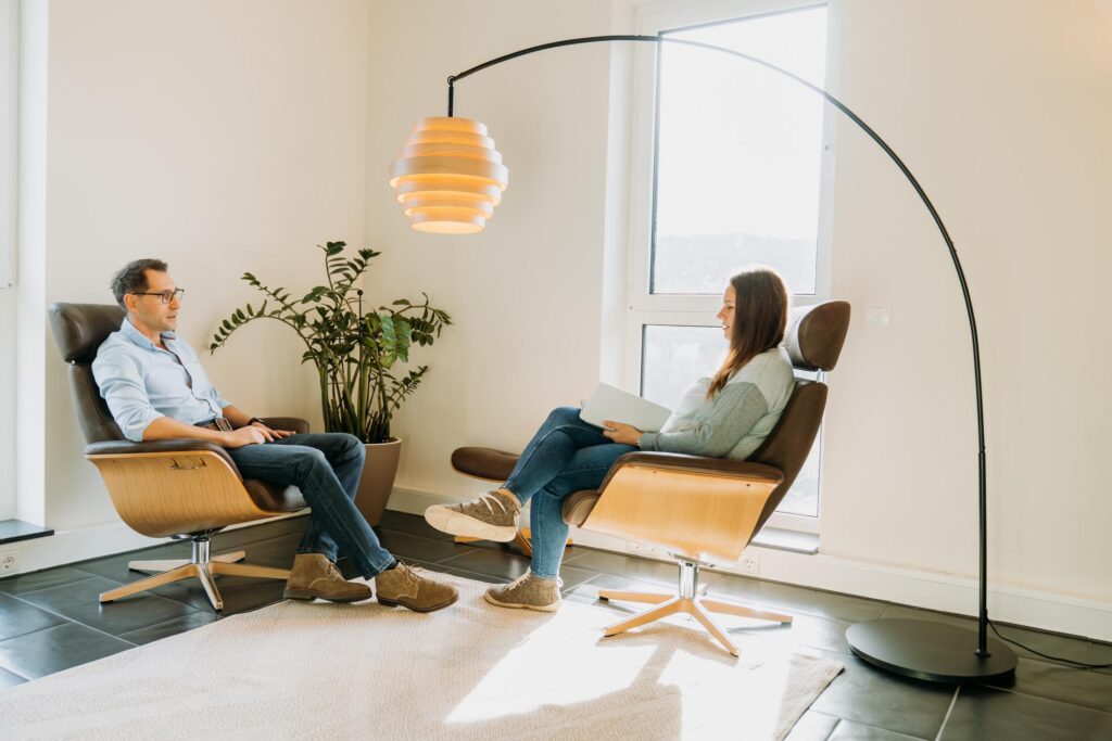 Dana Kaspar sitzt gegenüber eines Patienten im hellen Therapieraum
