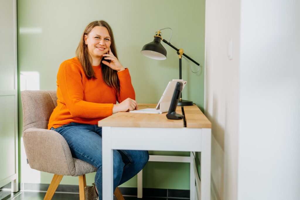 Dana Kaspar sitzt mit dem Laptop am Schreibtisch
